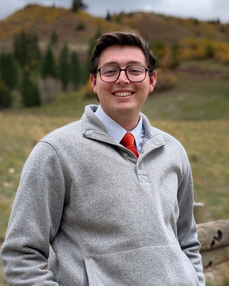 Gattlin Rogers, founder of Evergreen Doors, smiling outdoors in front of an autumn hillside